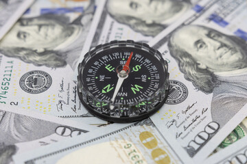 Classic navigational compass on the background of one hundred dollar bills