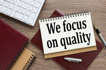 We focus on quality . business table. inscription on the notepad page. near the white keyboard