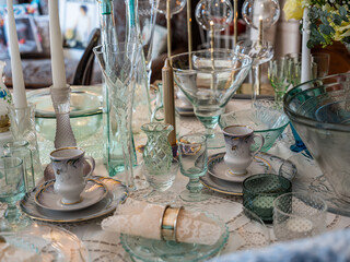 Stylish retro interior. Close-up of vintage glassware on table. Clean glasses. White candles.