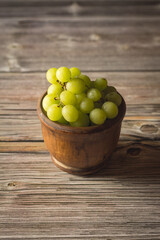 Bol en bois rempli de délicieux raisins verts