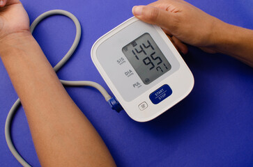 Digital pressure gauge: Person is checking blood pressure and heart rate with digital pressure gauge alone at home. Health and medical concept. Measurement of blood pressure and heart rate.