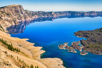 View of Crater Lake with mirror-like reflections on a calm and clear summer morning.