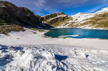 Alpine emerald lake and mountains at springtime, Gran Paradiso Alps, Italy