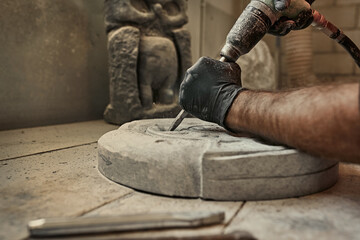 The craftsman works with stone with different tools. atmospheric photo. Sculpture making, handmade