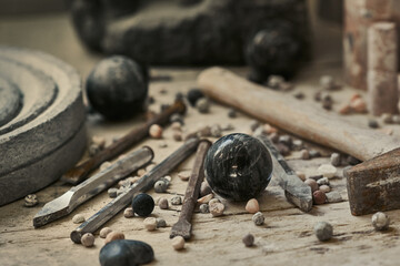 background with various tools for working with stone. Stone sculptures in the background in the workshop. hand made © svitlychnaja