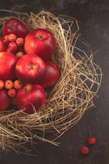Czerwone jabłka w słomianym koszyku