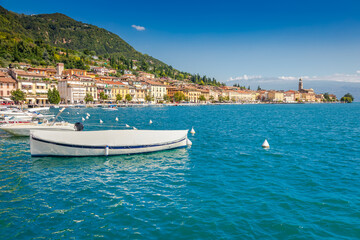 Fototapeta na wymiar Idyllic lake Garda coastline and mediterranean village with sailboats, Italy