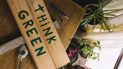 painting and writing with a brush a think green wooden sign to defend and support the care of the...