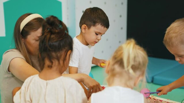 preschoolers playing with the kinetic sand with a big determination, kindergarten, creative activity. High quality 4k footage