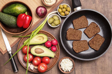 Cooking vegan vegetarian sandwich, snack with vegetable and toast of rye fried bread on kitchen. Healthy diet food concept	