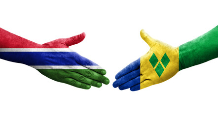 Handshake between Saint Vincent Grenadines and Gambia flags painted on hands, isolated transparent image.