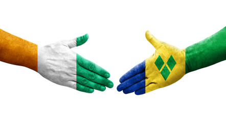 Handshake between Saint Vincent Grenadines and Ivory Coast flags painted on hands, isolated transparent image.