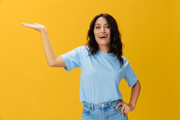 Woman signal smile with teeth emotion portrait in blue t-shirt on yellow background, hands up, surprise, lifestyle, copy space