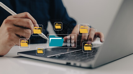 A paperless office built on e-documents. A man types on a laptop while viewing document icons on a virtual screen.