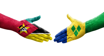 Handshake between Saint Vincent Grenadines and Mozambique flags painted on hands, isolated transparent image.