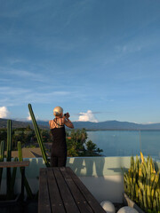 A woman enjoy beautiful landscape from roof top hotel in Lovina beach.