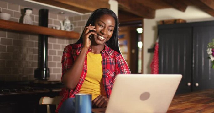 Pleasant smiling young African American woman holding cellphone call conversation.