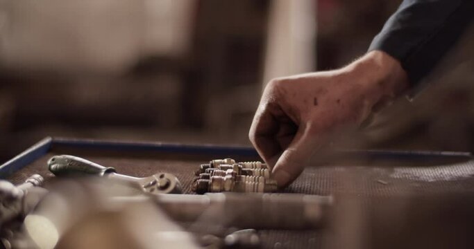 Crop technician arranging spar plugs on workbench