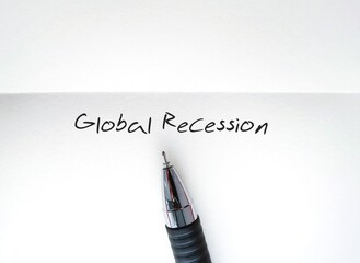 Pencil writing on white paper GLOBAL RECESSION, means the world economy is in trouble and going...
