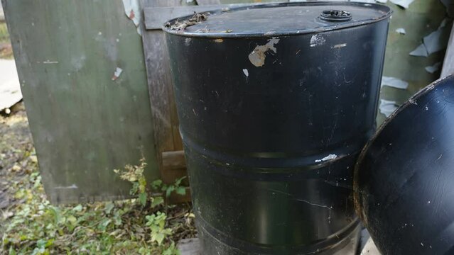 A tall black barrel for gasoline container on the side of the house in Estonia