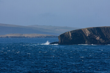 Cliffs and rocky coastline silhouette coast of Shetland Islands in Atlantic Ocean on sunny day with...