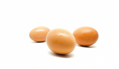 Three chicken eggs in a white background