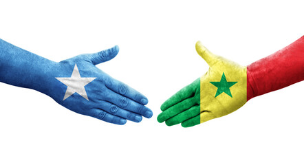 Handshake between Senegal and Somalia flags painted on hands, isolated transparent image.