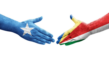 Handshake between Seychelles and Somalia flags painted on hands, isolated transparent image.