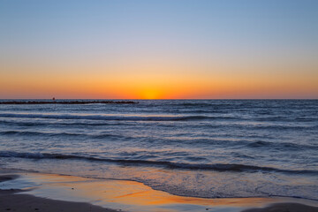 Fototapeta na wymiar Blue-orange sunset on the sea. The last ray