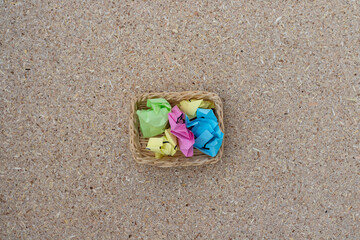 Fototapeta na wymiar Colorful crumbled sticky notes balls in a small basket. brainstorming concept.
