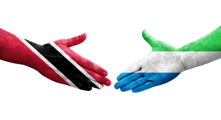 Obraz premium Handshake between Sierra Leone and Trinidad Tobago flags painted on hands, isolated transparent image.