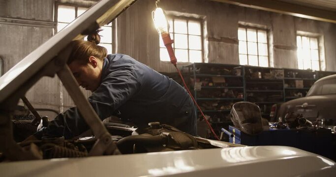 Male technician dismantling car engine