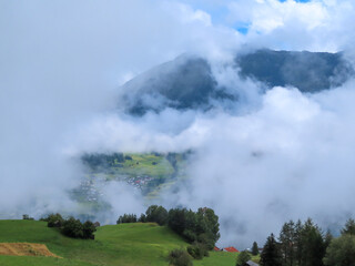 Wolken ziehen durch ein Tal in den Bergen
