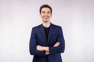 Portrait of young handsome businessman wearing suit standing with crossed arms with isolated on studio white background