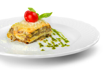 Close-up of tasty lasagna with tomato and basil on plate isolated on white background