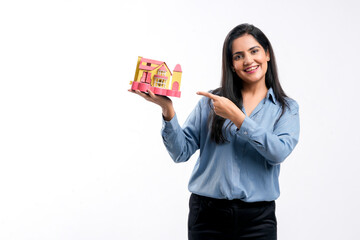 Indian woman holding home toy in hand. real estate concept.