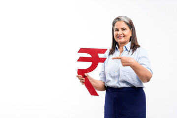 Indian senior lady holding rupees symbol in hand on white background.