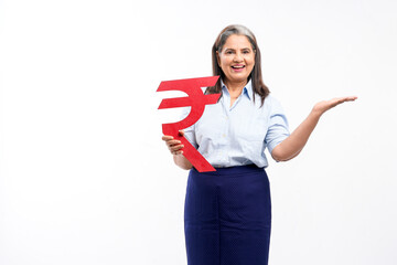 Indian senior lady holding rupees symbol in hand on white background.