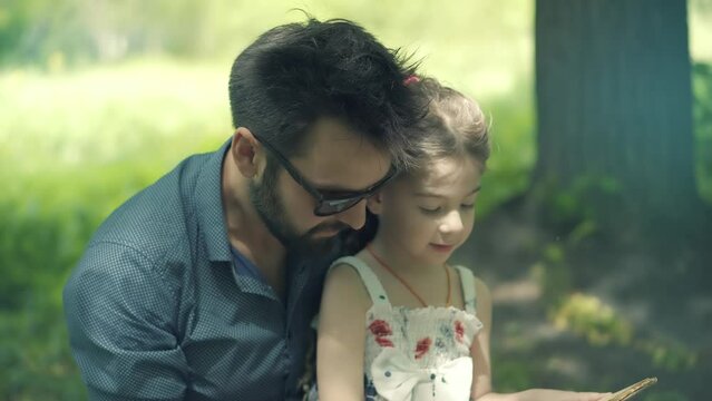 kid with father reading book. daddy reading fairy tale 
