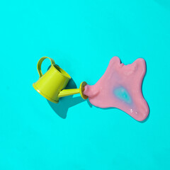 Creative minimalist layout. Watering can with slime on a blue background. Surreal summer idea. Conceptual pop