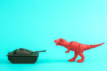 Toy red dinosaur tyrannosaurus rex with military tank on a turquoise background. Minimalism creative layout. Stop war