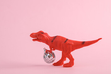 Toy two dinosaur tyrannosaurus rex with disco ball on pink background. Minimalism creative layout. Party concept