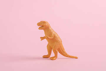 Toy dinosaur tyrannosaurus rex on pink background. Minimalism creative layout