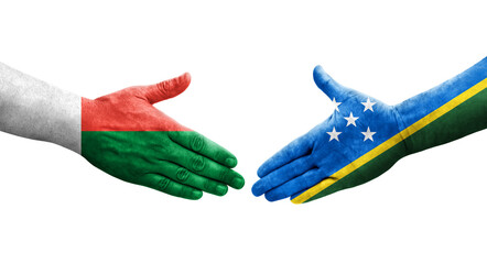 Handshake between Solomon Islands and Madagascar flags painted on hands, isolated transparent image.