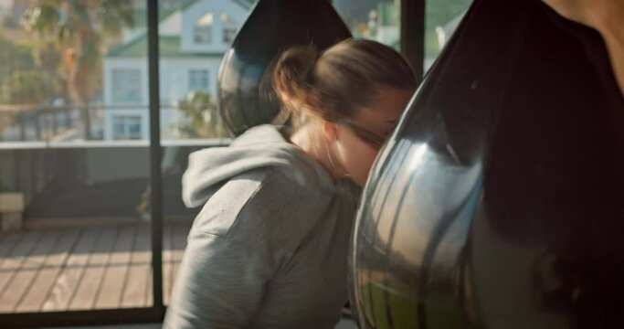 Boxer, woman and punching bag for exercise, training and workout for wellness, health and in gym. Martial arts, young female and healthy athlete practice, for competition and fitness being strong.