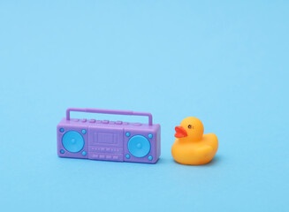 Rubber duck with boombox audio player on blue background