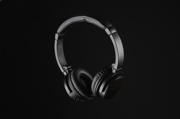 Fototapeta na wymiar Black wireless stereo headphones isolated on black background