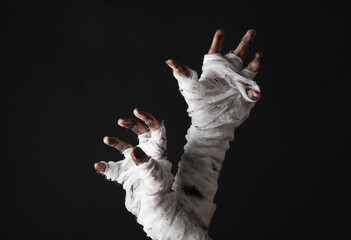 Mummy hands wrapped in a bandage isolated on a black background. Halloween concept
