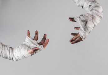 Mummy hands wrapped in a bandage isolated on gray background. Halloween concept