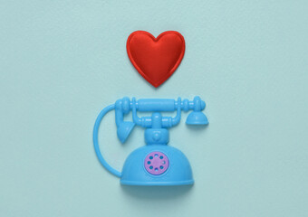 Toy Retro rotary phone with heart on blue background. Romantic, love, valentine's day concept